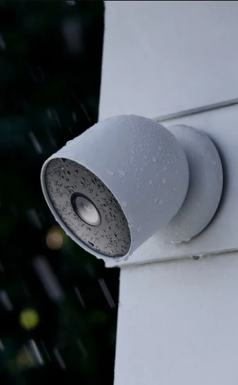 google nest cam buiten op een muur in de regen