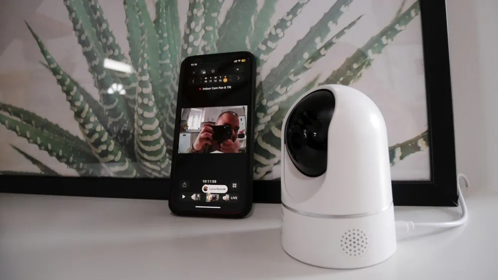 ip camera met iphone ernaast waarop te zien is dat iemand een foto maakt van de camera