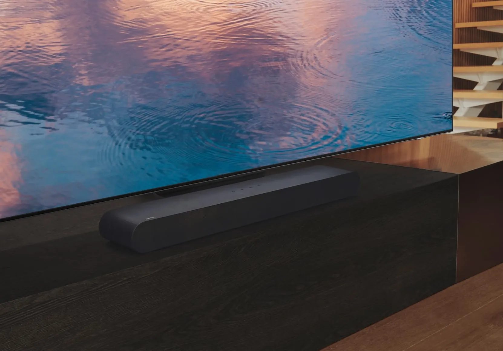 Samsung HW-S60B sounbar op een tv-meubel onder een tv