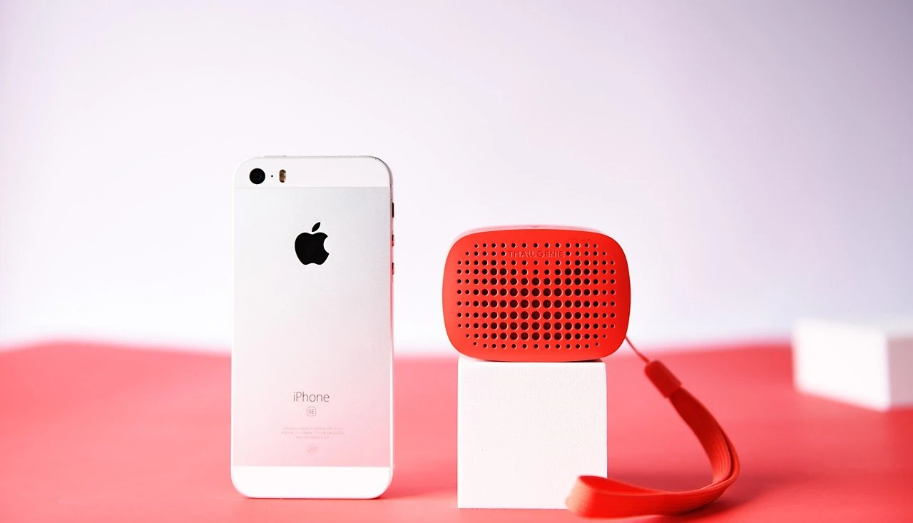 Rood Bluetooth speakertje naast iPhone