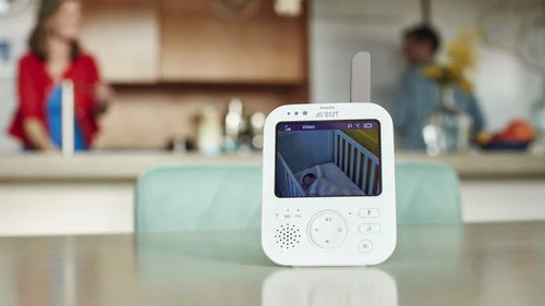 De Philips Avent SCD84301 babyfoon met camera staat op de keukentafel, terwijl moeder in de keuken bezig is