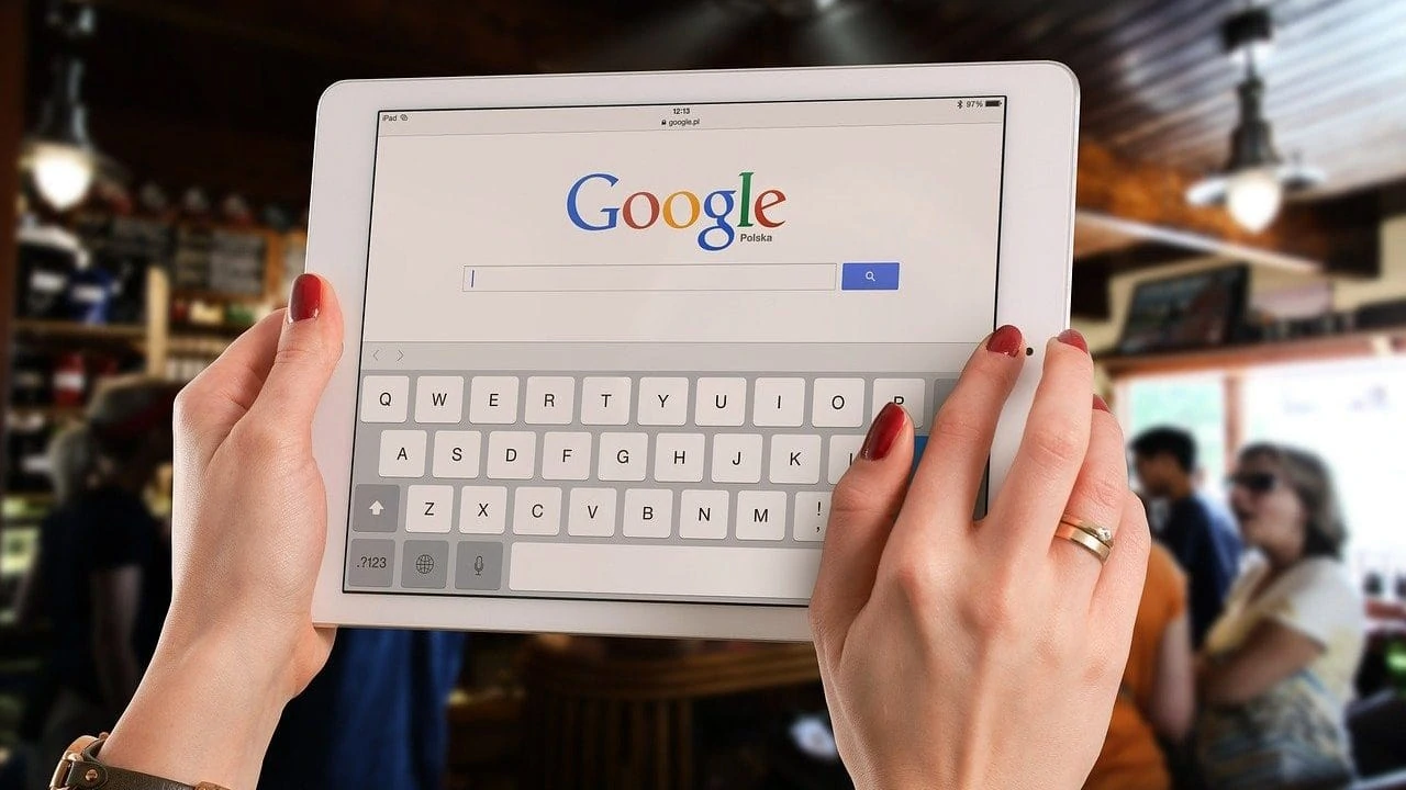 Handen houden tablet met Google op scherm omhoog