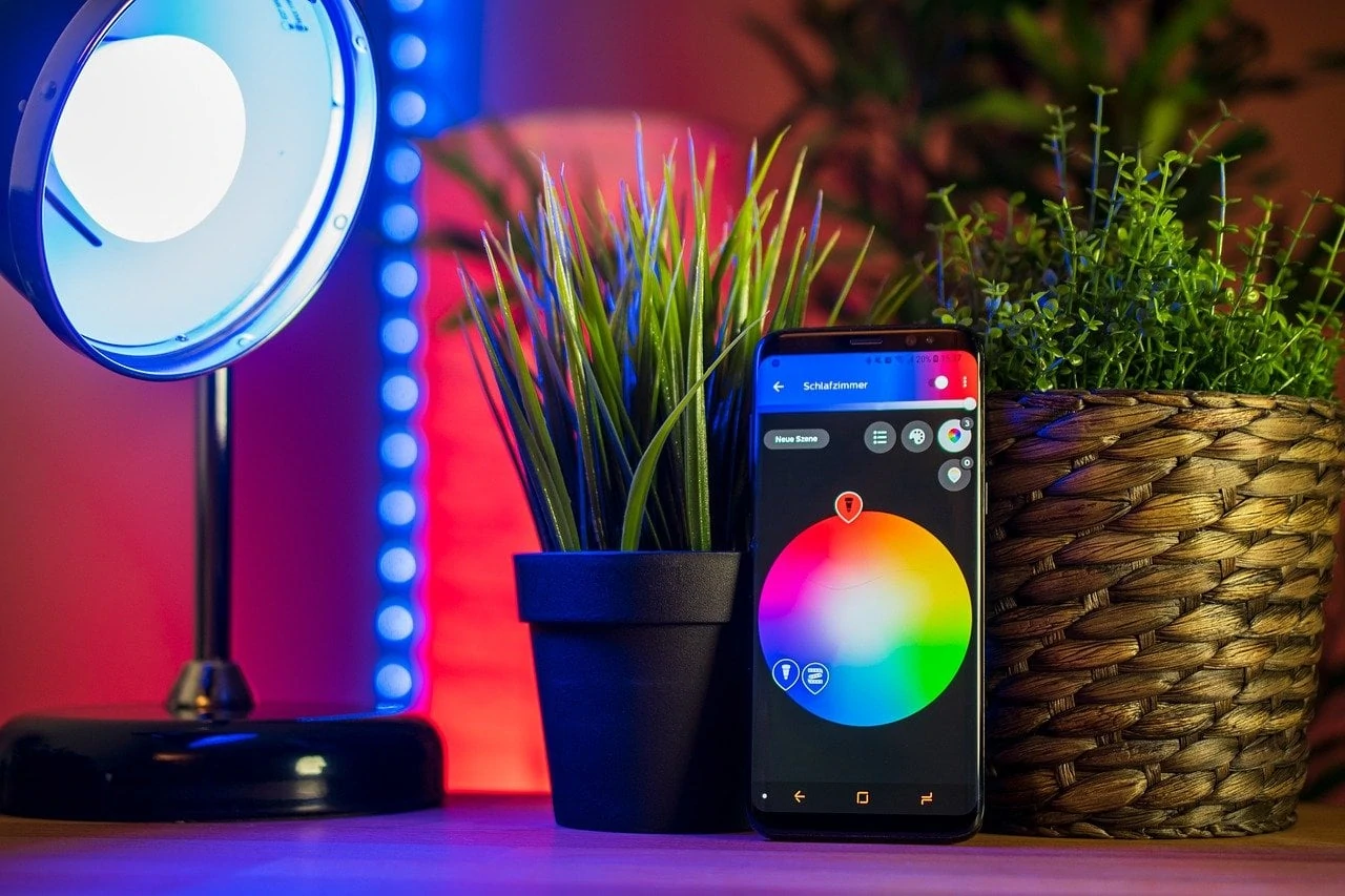 Smartphone, gekleurde lamp en planten