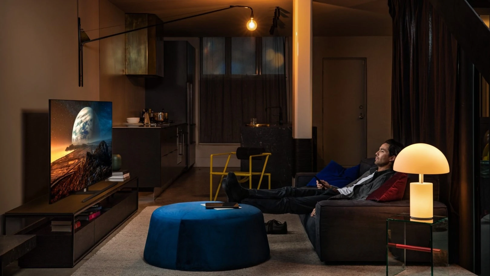 Persoon kijkt tv in een gezellige donkere ruimte met sfeerverlichting