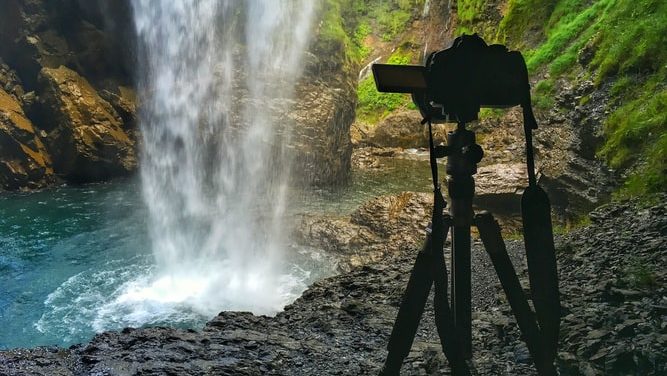 Camera op een statief bij een waterval