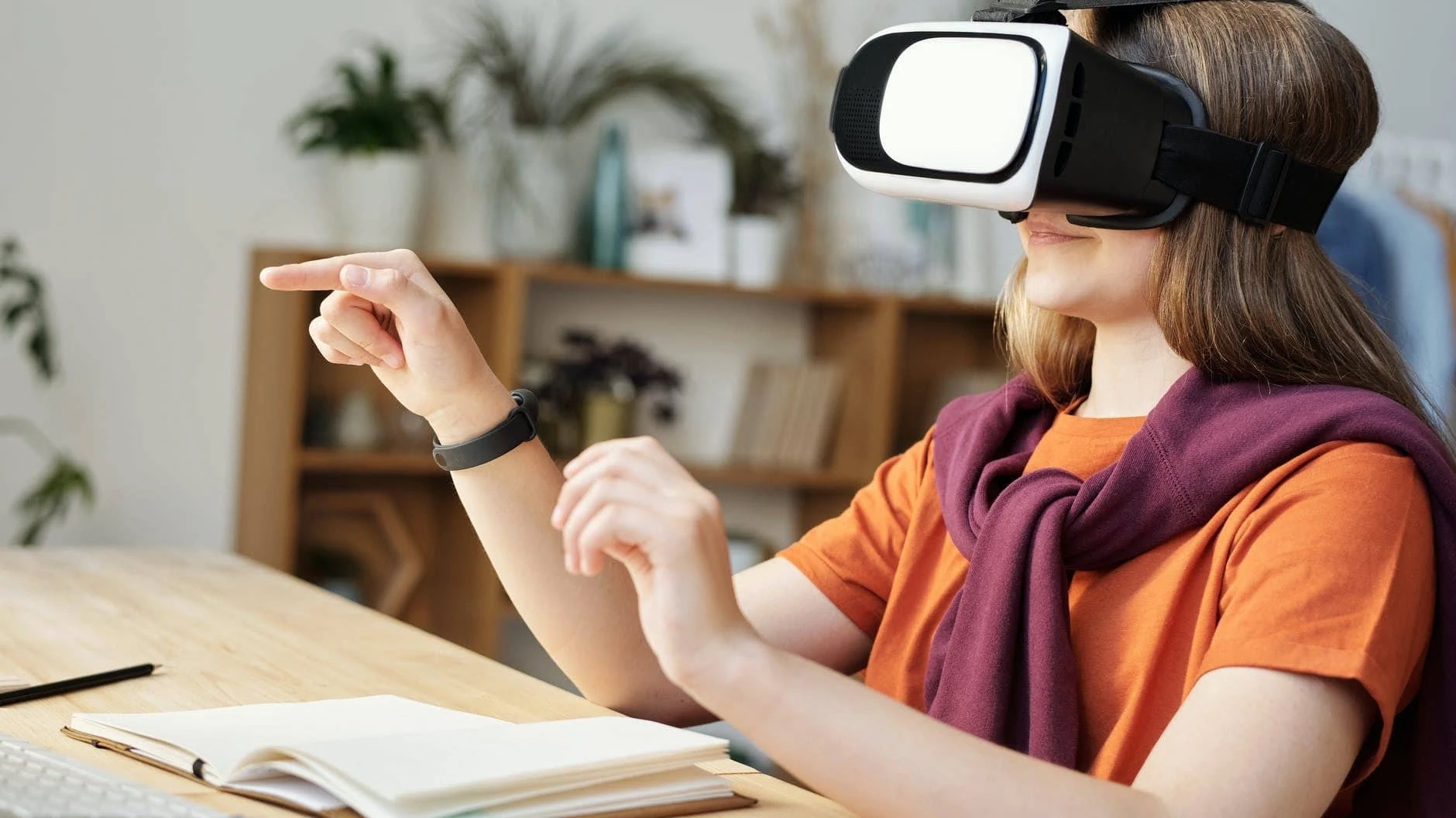 Meisje zit aan haar bureau met een VR-bril