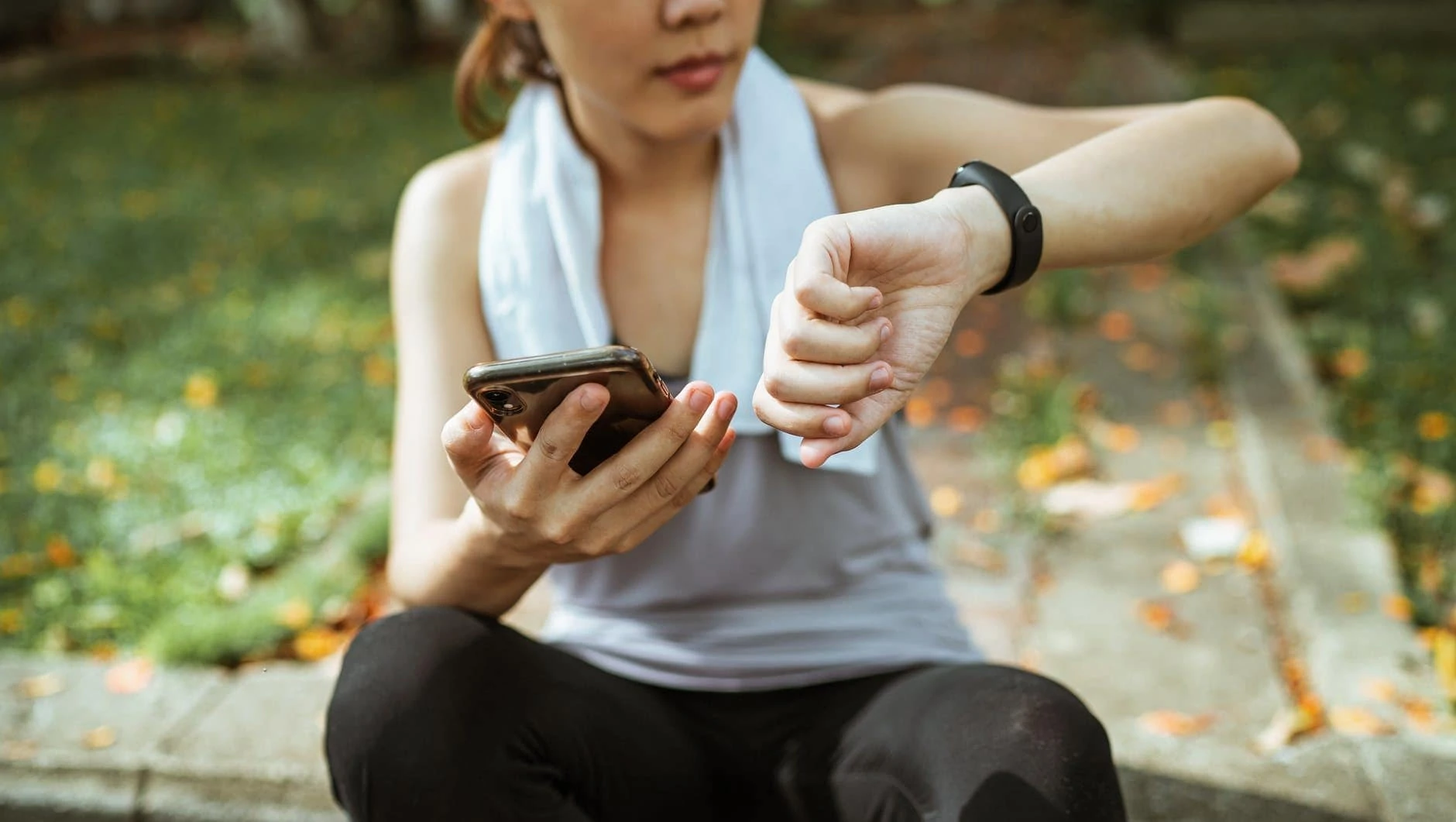 Vrouw bekijkt de resultaten van haar activity tracker op haar smartphone