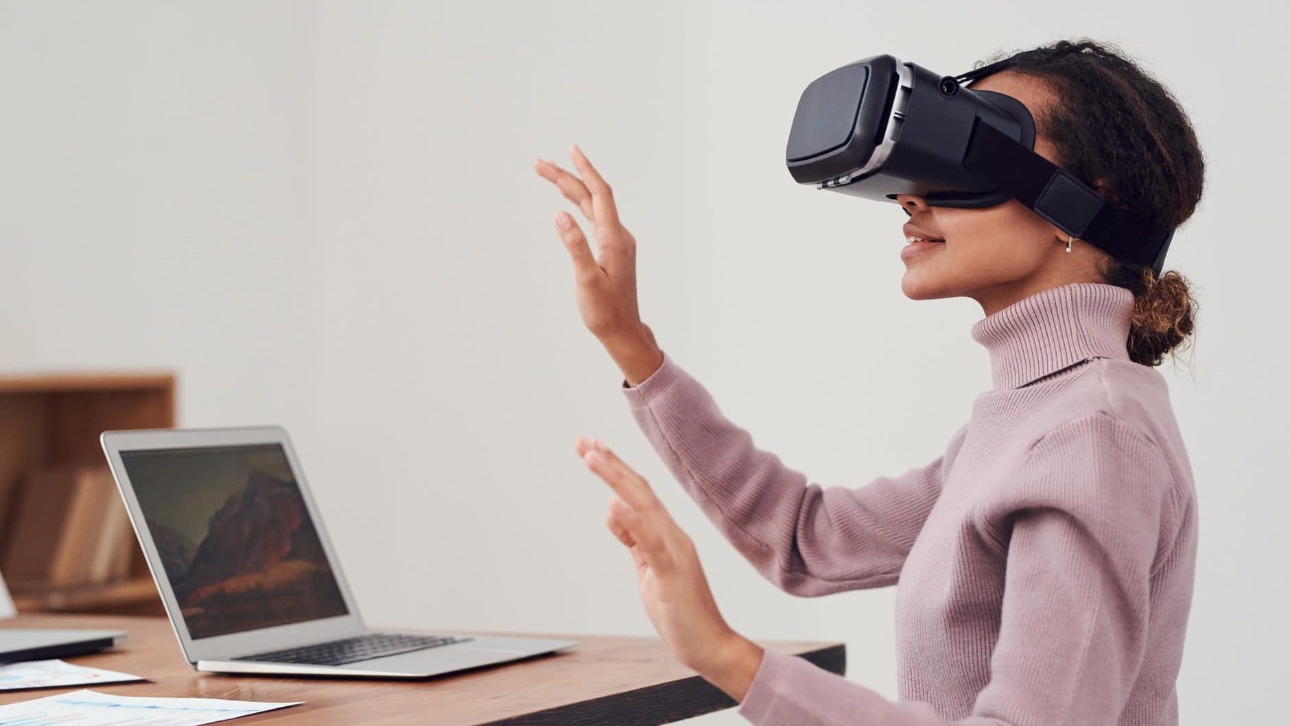 Vrouw zit aan haar bureau met een VR-bril