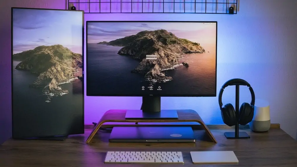 dual monitor set up met een verticale monitor en paarse verlichting