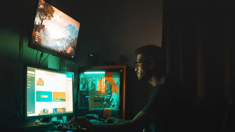 Persoon in een donkere kamer voor een monitor
