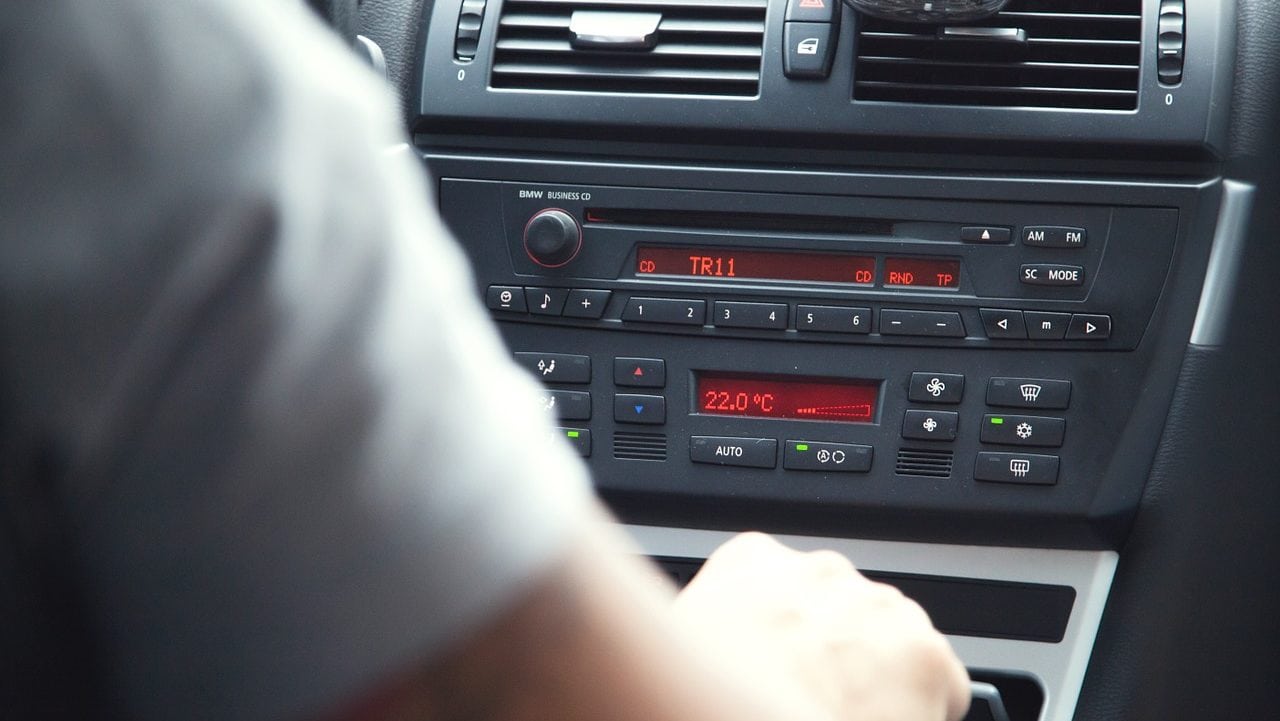 persoon in de auto bedient de radio