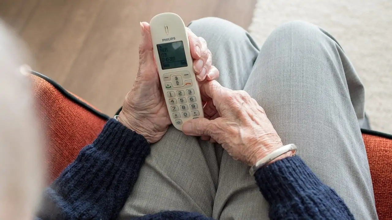ouder persoon met telefoon in hand