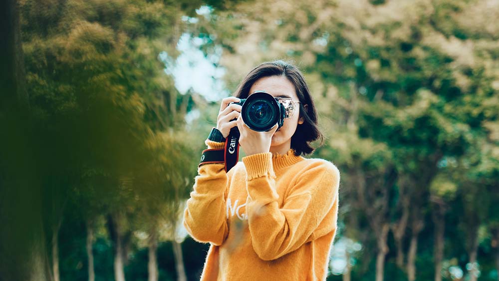 vrouw fotografeert met haar digitale camera in de natuur
