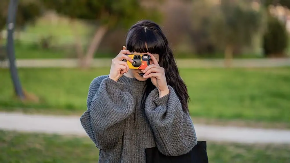 Vrouw neemt een foto met een wegwerpcamera