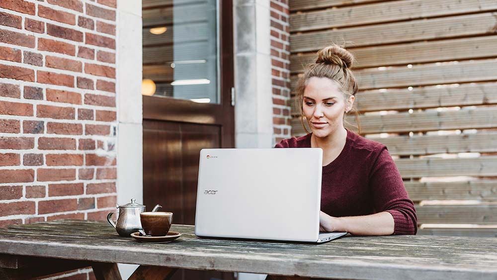 Vrouw werkt buiten op haar laptop