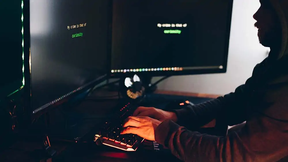 Man in een donkere ruimte voor zijn computer