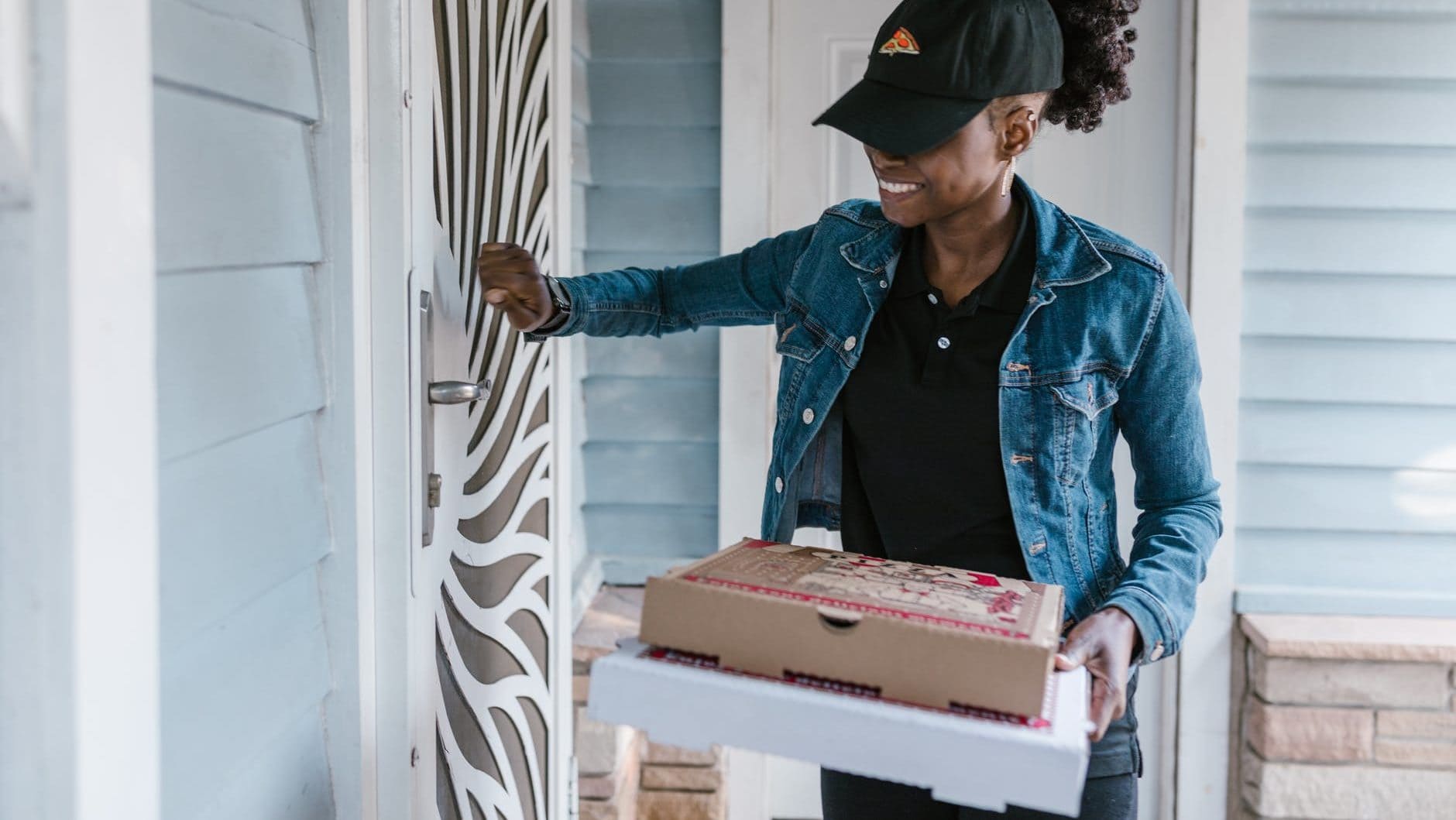 Vrouw levert pizza aan de voordeur