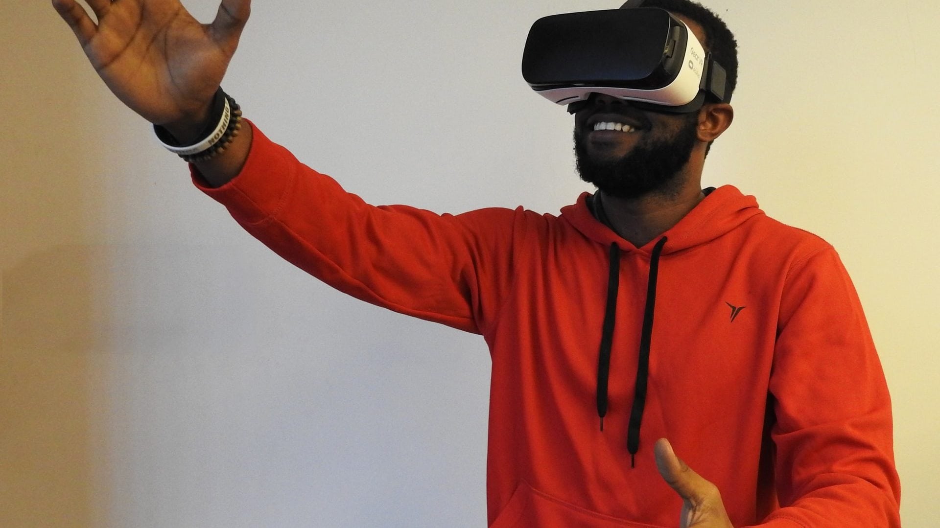 man in rode trui met virtual reality bril