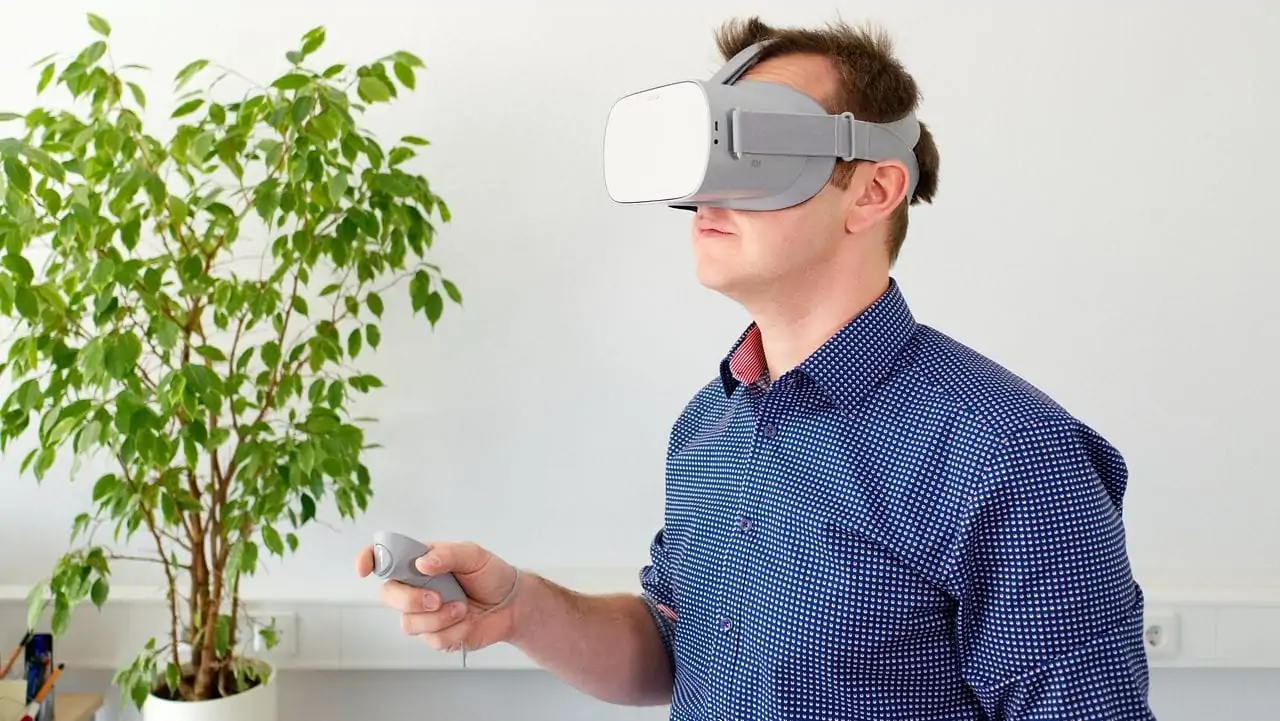 man met virtual reality bril naast een plant