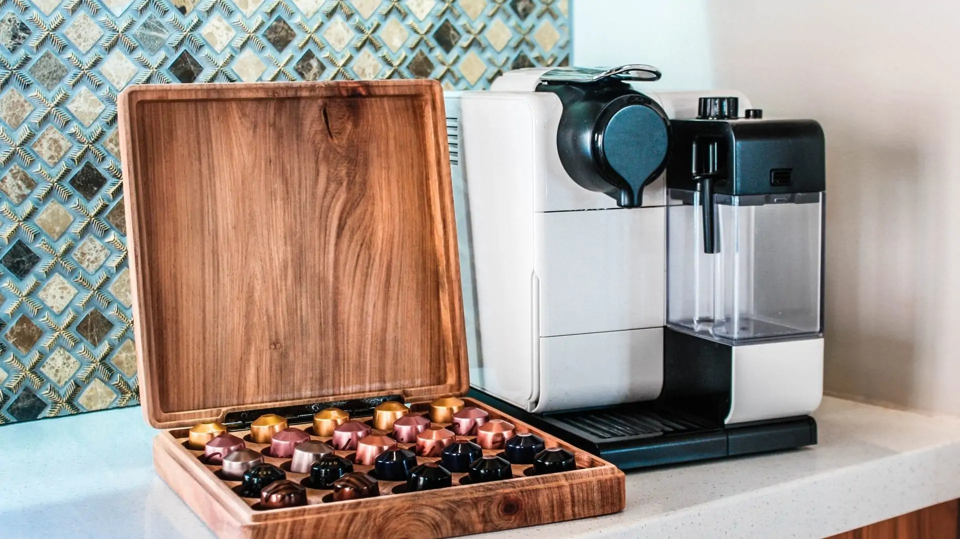 Nespresso-apparaat met een houten doos met cupjes erin ernaast