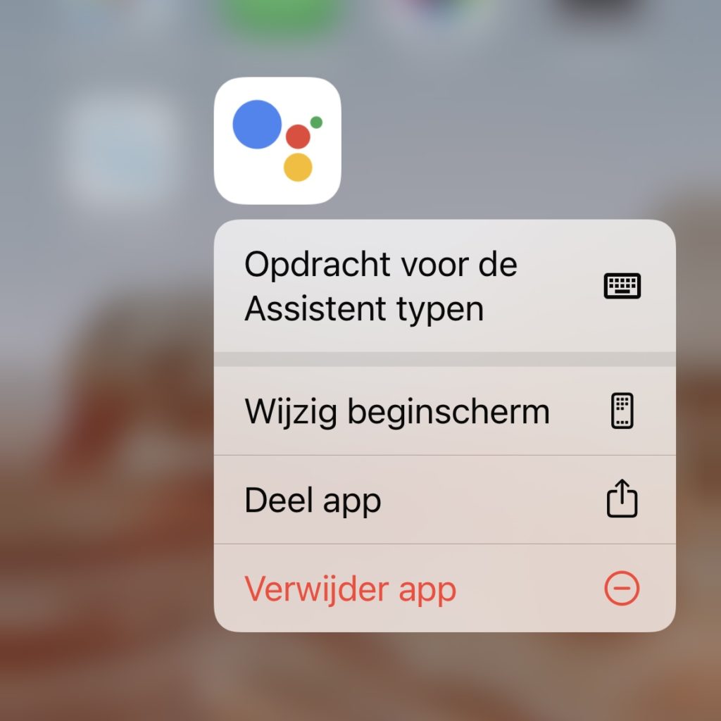 Apple apparaat scherm waarop de Google Assistent app is geselecteerd met daaronder een menu met meerdere opties
