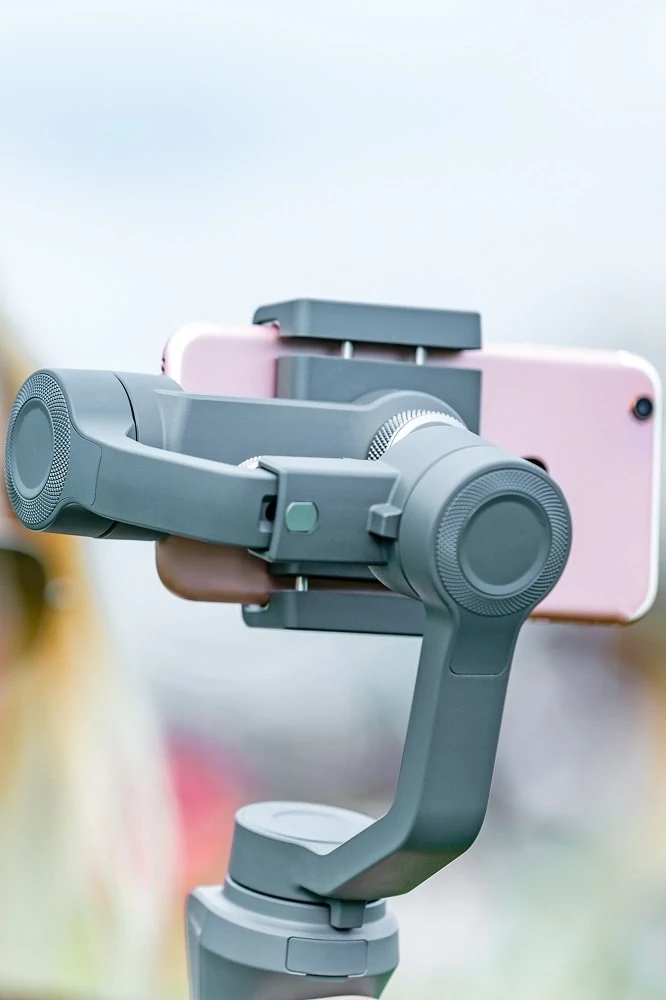 Een grijze gimbal met een roze smartphone