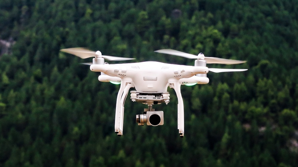 Een witte drone met daaronder een gimbal met camera