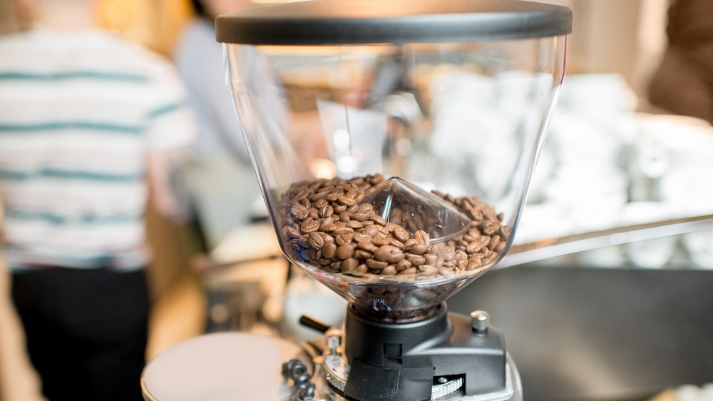 Elektrische koffiemolen met een conische maalschijf, gevuld met koffiebonen