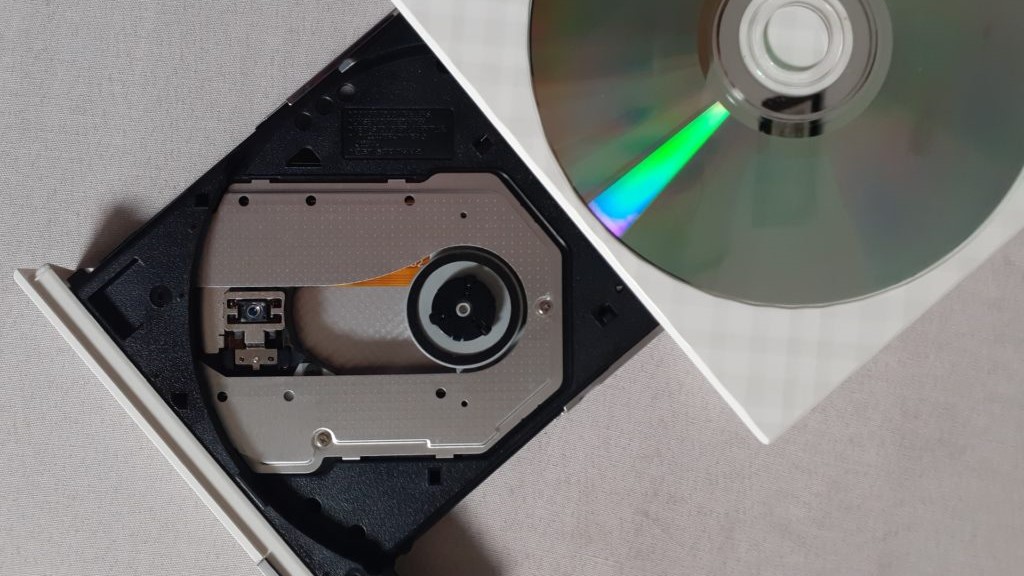 witte dvd-speler opent met losse dvd die erop ligt
