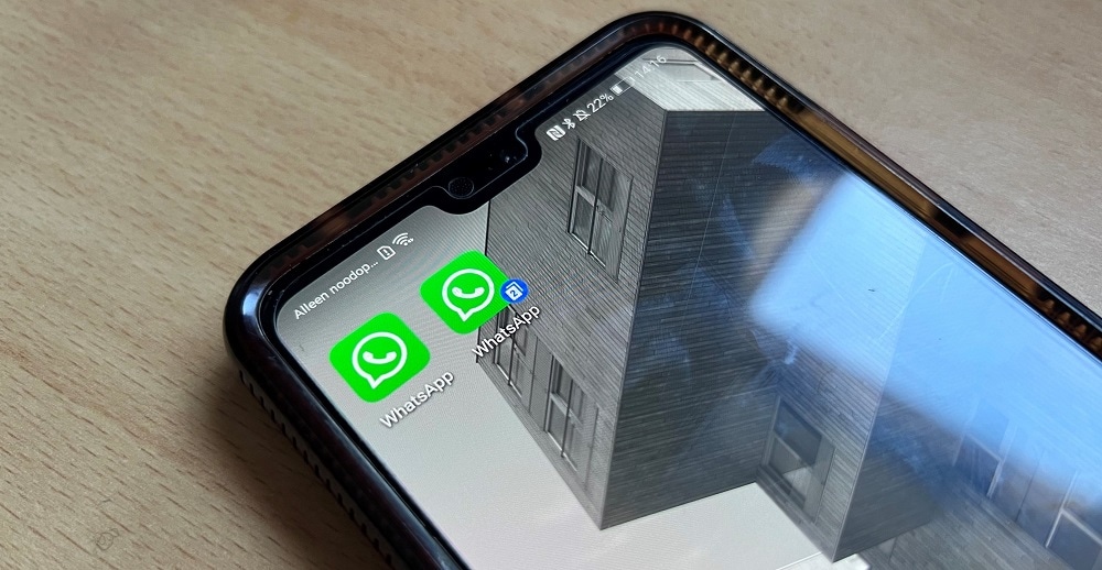 Close-up van een smartphone met WhatsApp dual-sim op een houten ondergrond