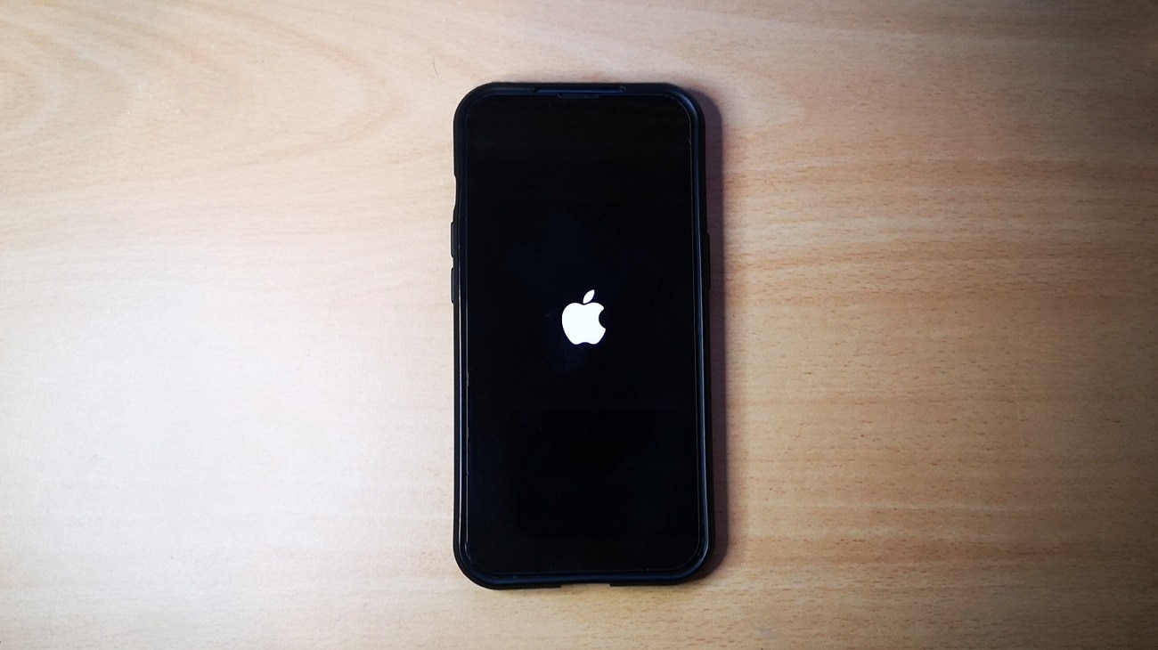 IPhone met het Apple logo op het scherm op een houten ondergrond