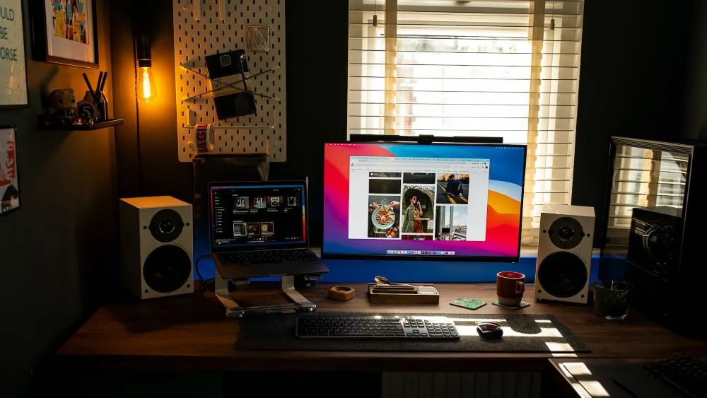 bureau met monitor erop naast laptop en randapparatuur