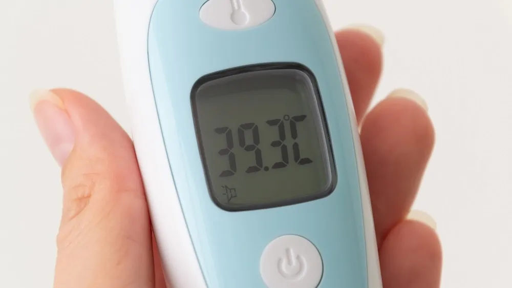 Close-up van het display van een oorthermometer met daarop de gemeten temperatuur van 39,3 graden Celsius