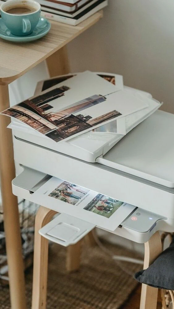 Witte printer print meerdere A4-vellen uit met daarop afbeeldingen in kleur