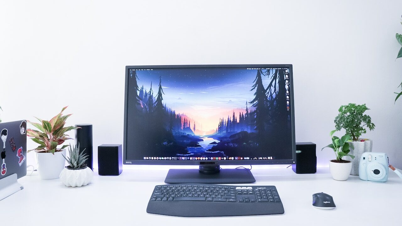 Een monitor in huis op een bureau met toetsenbord en muis