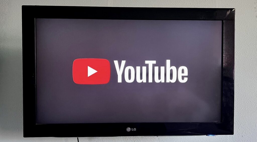 Zwarte televisie aan de muur met daarop YouTube geopend