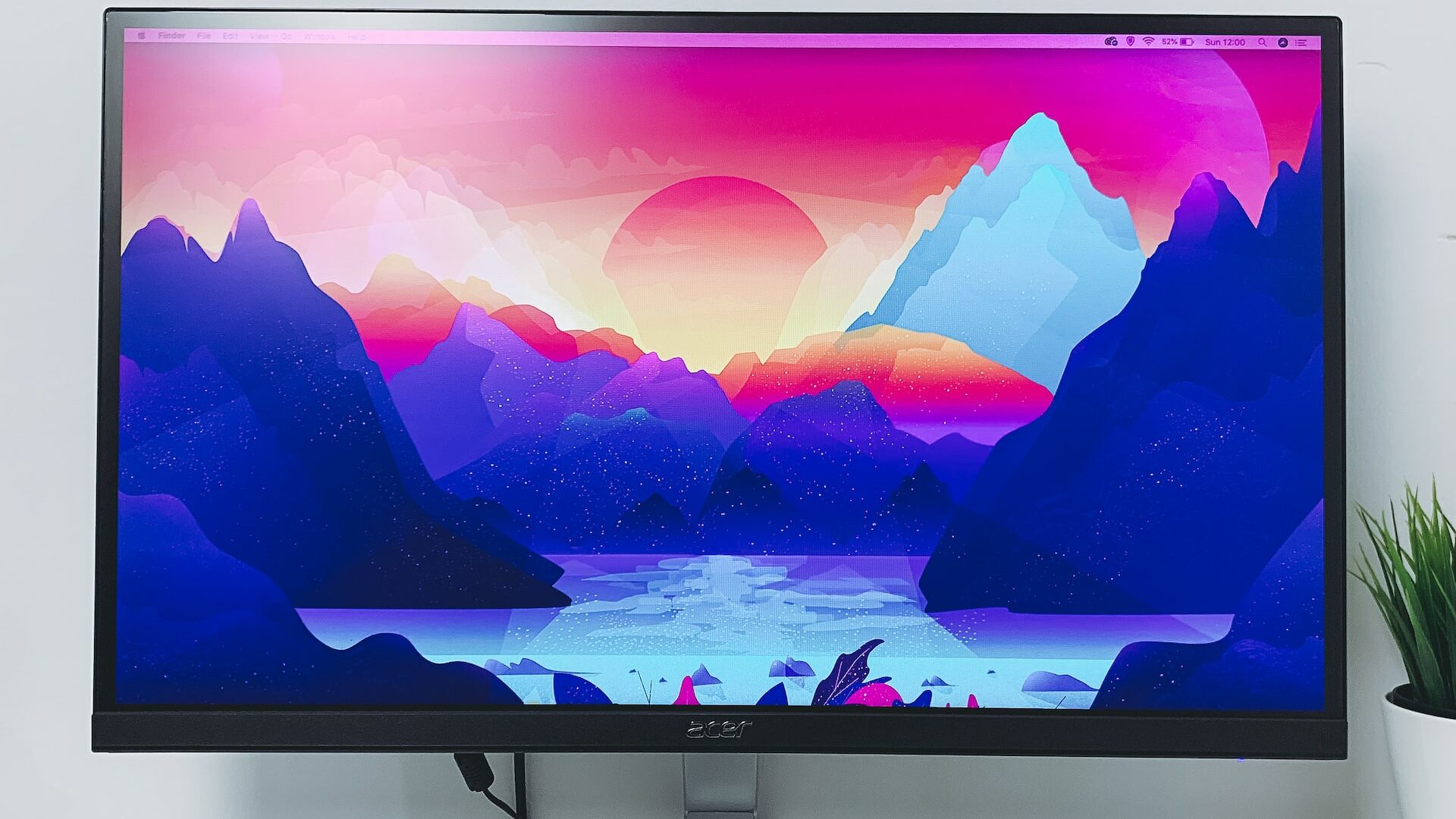 Een monitor met daarop een kleurrijk artistiek landschap