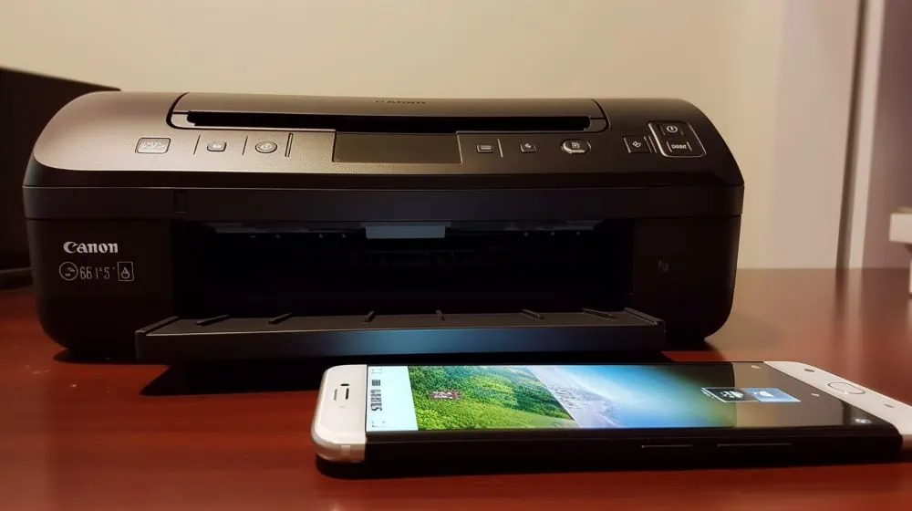 illustratie van canon printer met een smartphone ervoor op een houten tafel